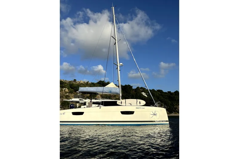 Knotty Cat Yacht Photos Pics 2022 Fountaine Pajot Tanna 47 catamaran sailing on calm waters under a blue sky.