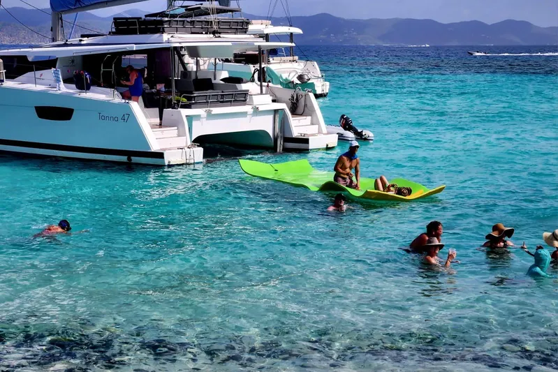 Knotty Cat Yacht Photos Pics 2022 Fountaine Pajot Tanna 47 catamaran with people enjoying turquoise waters.