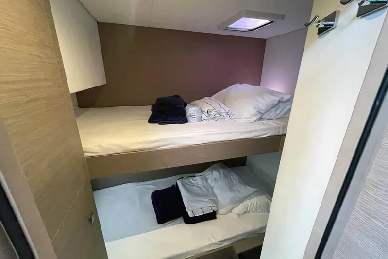 Knotty Cat Yacht Photos Pics 2022 Fountaine Pajot Tanna 47 cabin with bunk beds and neatly arranged linens.