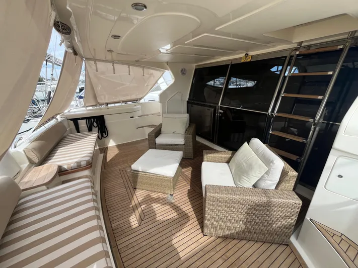  Yacht Photos Pics Luxurious 2000 Ferretti Yachts 620 interior with wicker seating and striped cushions.