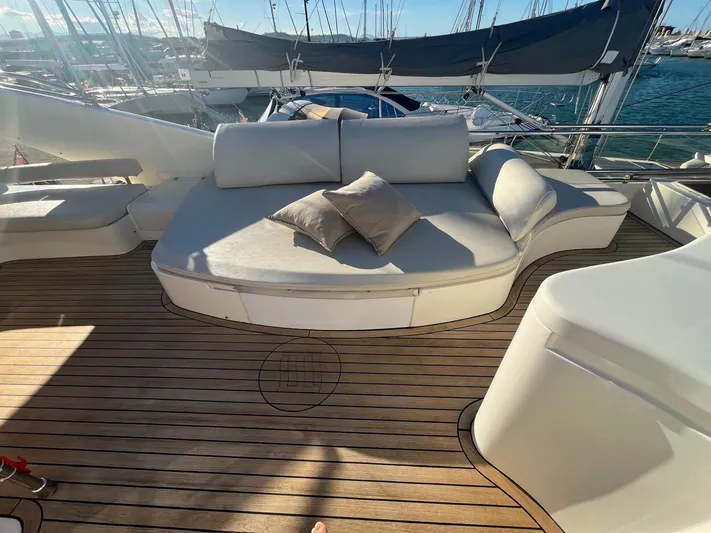  Yacht Photos Pics Luxurious seating area on a 2000 Ferretti Yachts 620, with wooden deck and cushions.