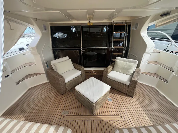  Yacht Photos Pics Luxurious 2000 Ferretti Yachts 620 interior with wicker seating and wooden flooring.
