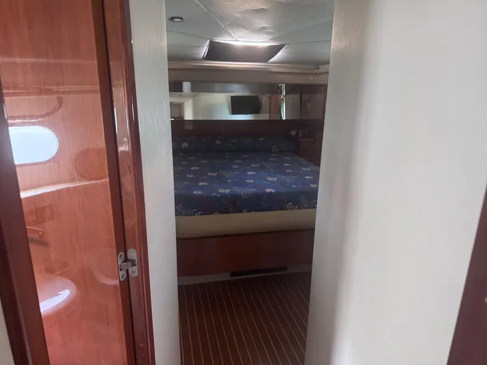  Yacht Photos Pics Interior cabin of 2000 Ferretti Yachts 620, featuring a cozy bed and wooden finishes.