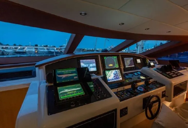  Yacht Photos Pics Control panel of 2004 Mangusta 108 yacht with navigation screens and steering wheel.