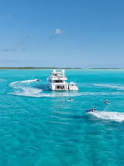 Mambo Yacht Photos Pics Luxurious 2004 Ferretti Yachts 112 Custom Line cruising in turquoise waters with jet skis nearby.