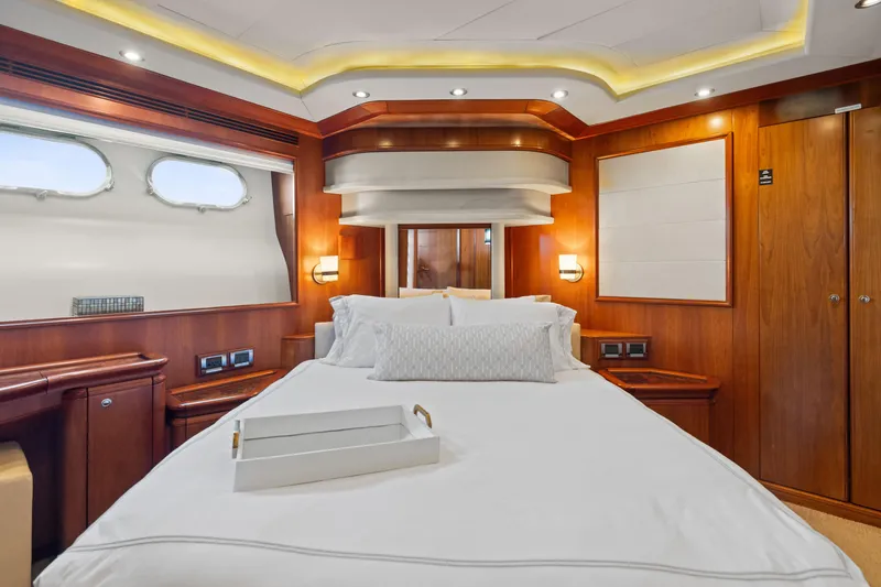 Mambo Yacht Photos Pics Luxurious bedroom interior of 2004 Ferretti Yachts 112 Custom Line, featuring elegant wood paneling.