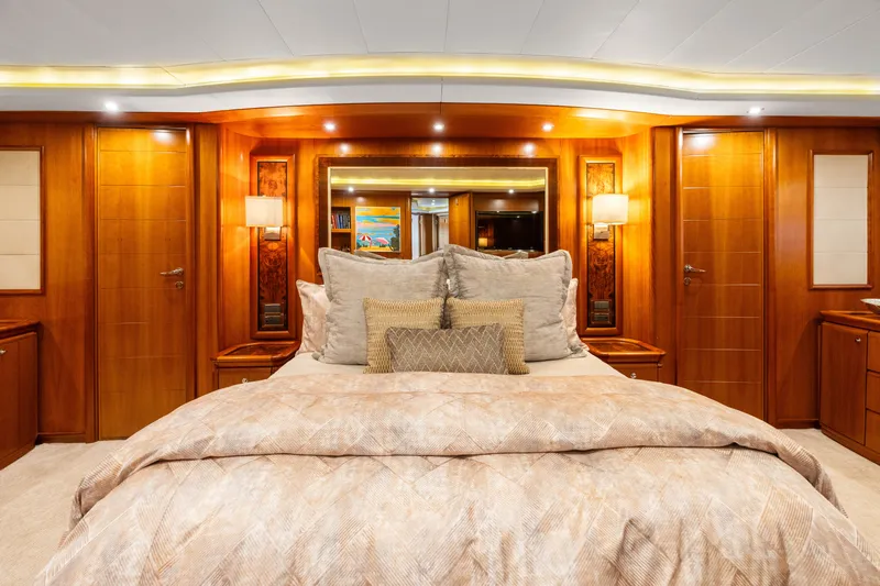 Mambo Yacht Photos Pics Luxurious bedroom interior of 2004 Ferretti Yachts 112 Custom Line, featuring elegant wood paneling.