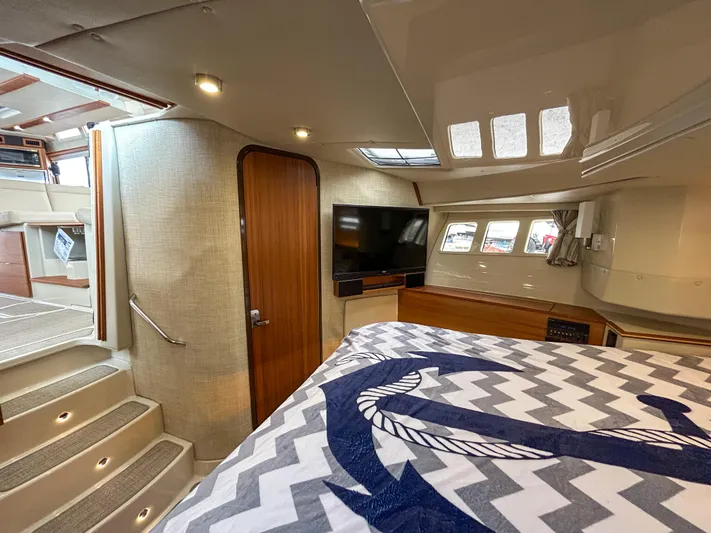  Yacht Photos Pics 2023 Ranger Tugs R-43 CB interior cabin with bed, TV, and stairs.