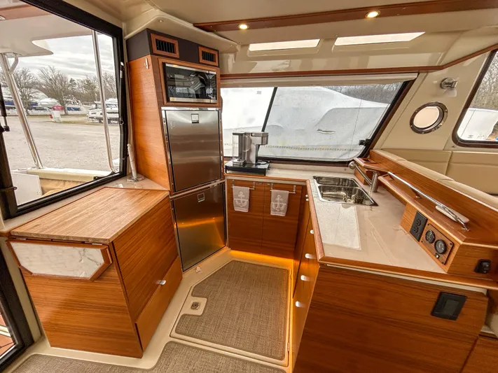  Yacht Photos Pics Interior of 2023 Ranger Tugs R-43 CB yacht, featuring modern kitchen with wood cabinetry and stainless appliances.