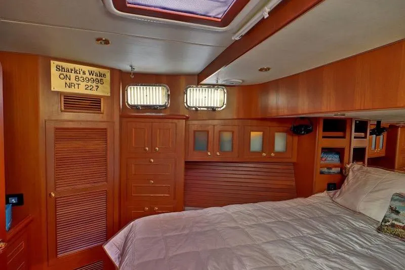 Sharki's Wake Yacht Photos Pics Cozy cabin interior of 2016 North Pacific 45 Pilothouse with wood finish and bed.