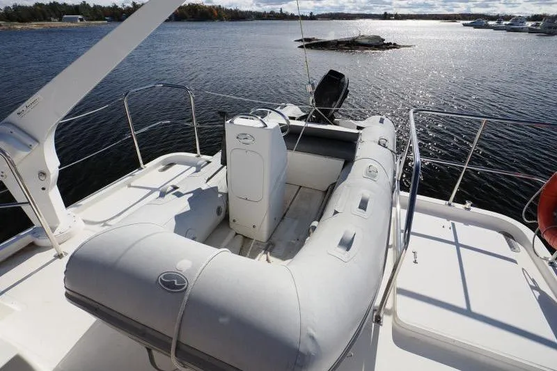 Sharki's Wake Yacht Photos Pics 2016 North Pacific 45 Pilothouse with inflatable dinghy on deck, overlooking serene waters.