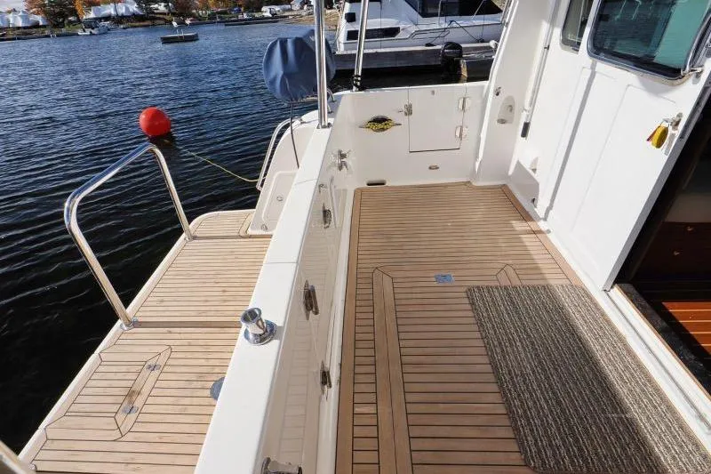 Sharki's Wake Yacht Photos Pics 2016 North Pacific 45 Pilothouse boat deck with teak flooring by the water.