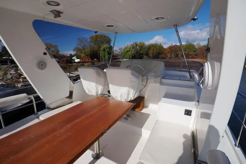 Sharki's Wake Yacht Photos Pics 2016 North Pacific 45 Pilothouse yacht deck with seating and steering wheel.