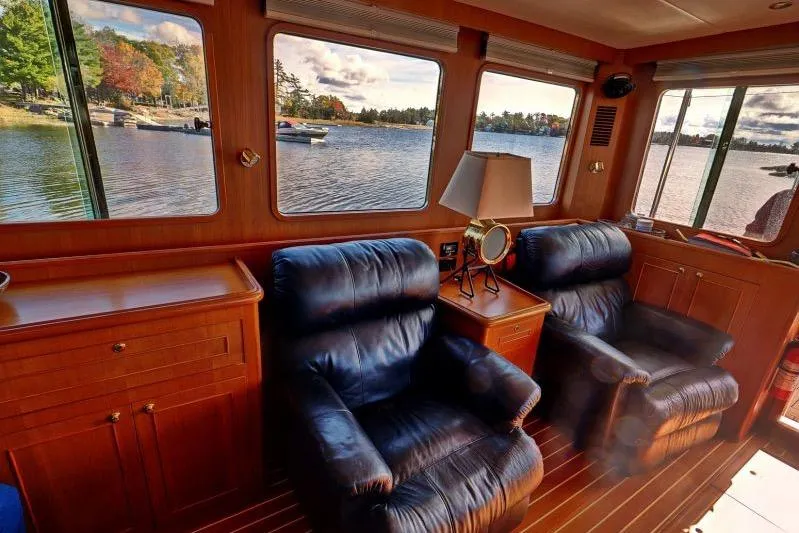 Sharki's Wake Yacht Photos Pics Luxurious interior of 2016 North Pacific 45 Pilothouse with leather chairs and scenic windows.