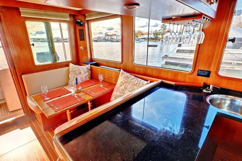 Sharki's Wake Yacht Photos Pics Luxurious interior of 2016 North Pacific 45 Pilothouse yacht with dining area and waterfront view.