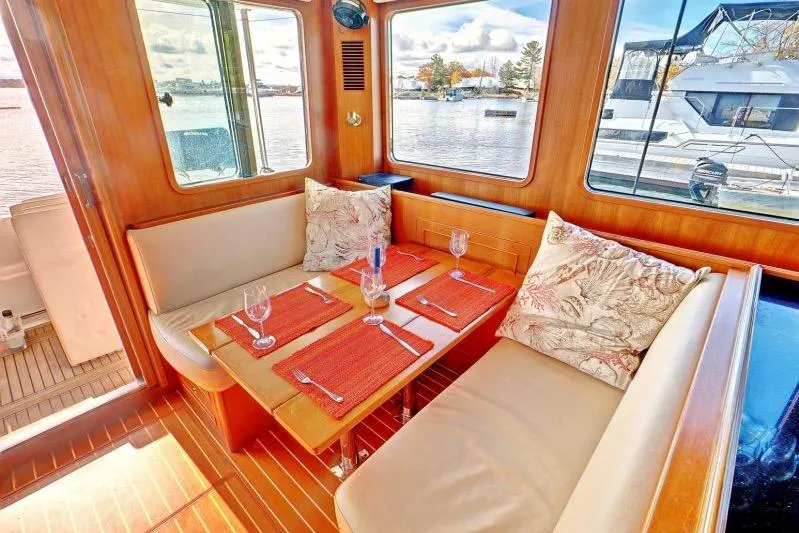 Sharki's Wake Yacht Photos Pics Interior of 2016 North Pacific 45 Pilothouse with dining area and scenic windows.