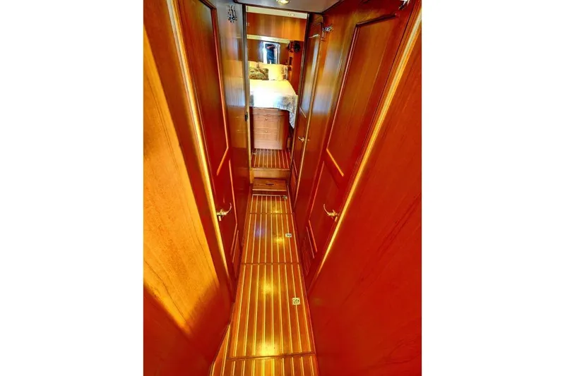 Sharki's Wake Yacht Photos Pics Narrow wooden hallway inside 2016 North Pacific 45 Pilothouse yacht, leading to a cozy cabin.