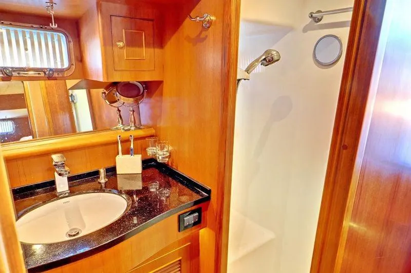 Sharki's Wake Yacht Photos Pics Luxurious bathroom in 2016 North Pacific 45 Pilothouse yacht with wood accents and modern fixtures.