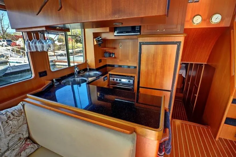 Sharki's Wake Yacht Photos Pics Luxurious 2016 North Pacific 45 Pilothouse yacht interior with modern kitchen amenities.