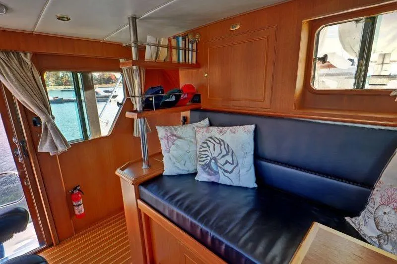 Sharki's Wake Yacht Photos Pics Interior of 2016 North Pacific 45 Pilothouse with cozy seating and nautical decor.