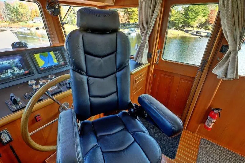 Sharki's Wake Yacht Photos Pics Pilothouse interior of 2016 North Pacific 45, featuring captain's chair and navigation equipment.