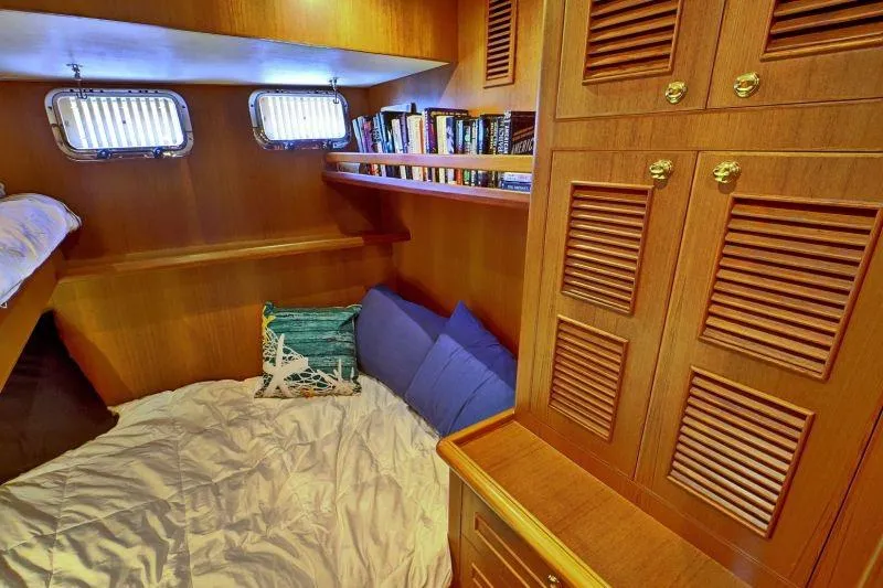 Sharki's Wake Yacht Photos Pics Cozy cabin interior of 2016 North Pacific 45 Pilothouse with books and bedding.