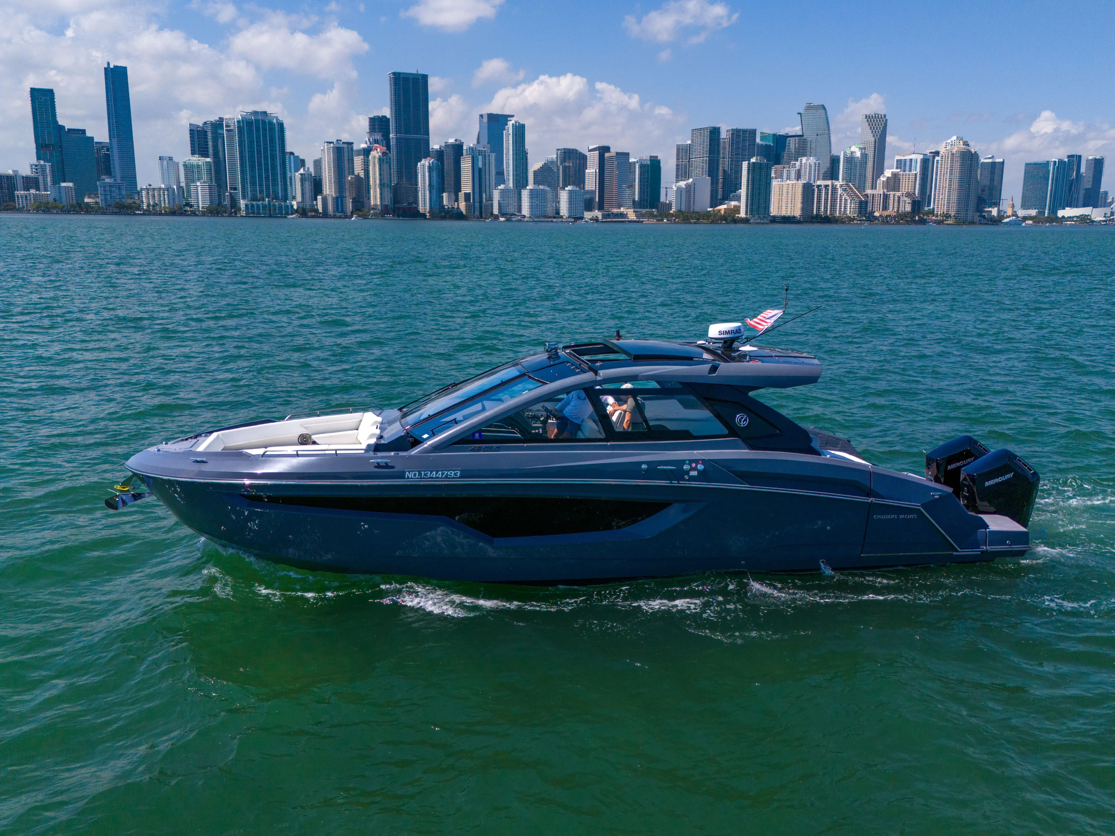  Yacht Photos Pics 2023 Cruisers Yachts 42 GLS OB on water with city skyline backdrop.