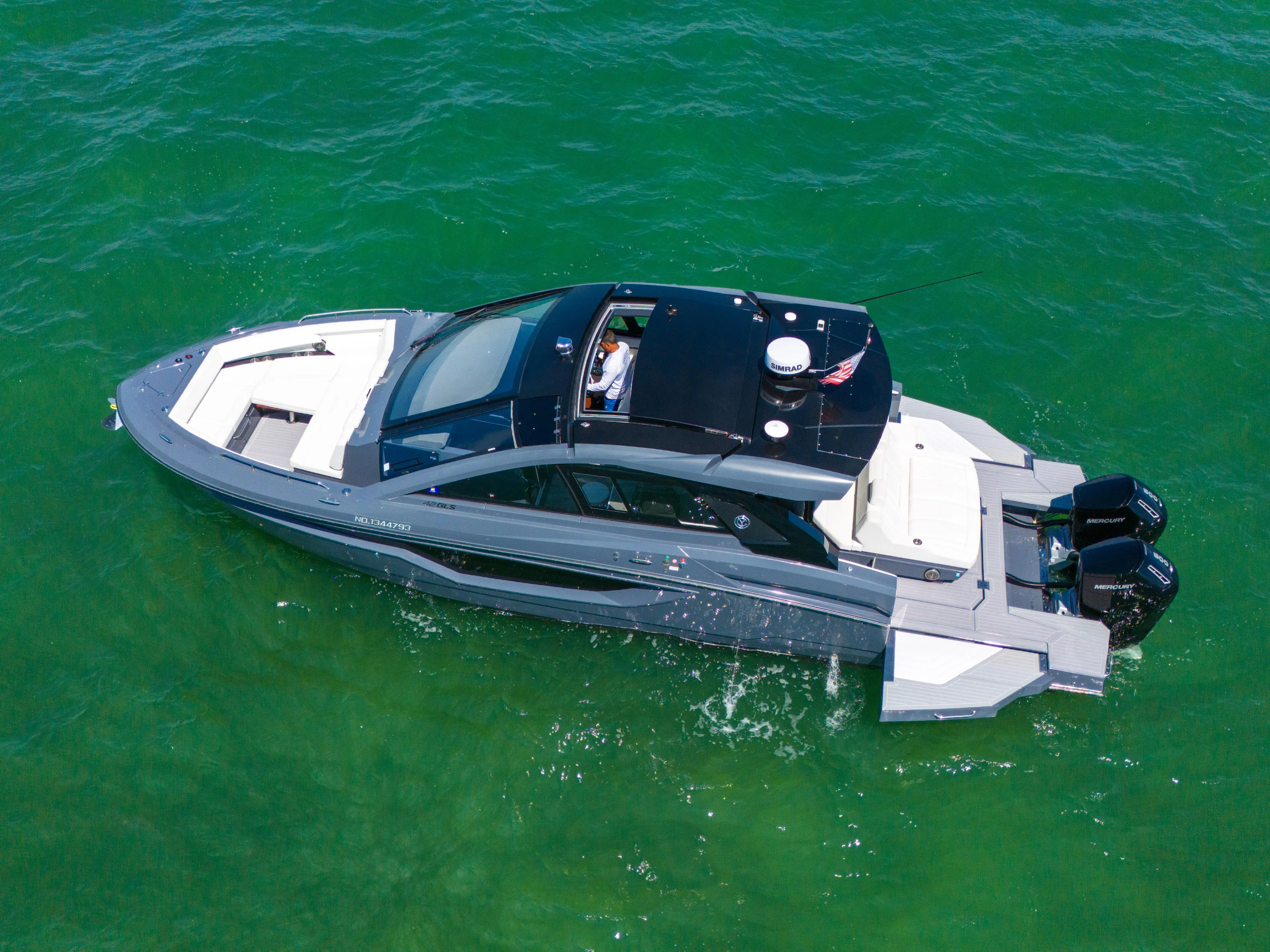  Yacht Photos Pics 2023 Cruisers Yachts 42 GLS OB on vibrant green water, aerial view.