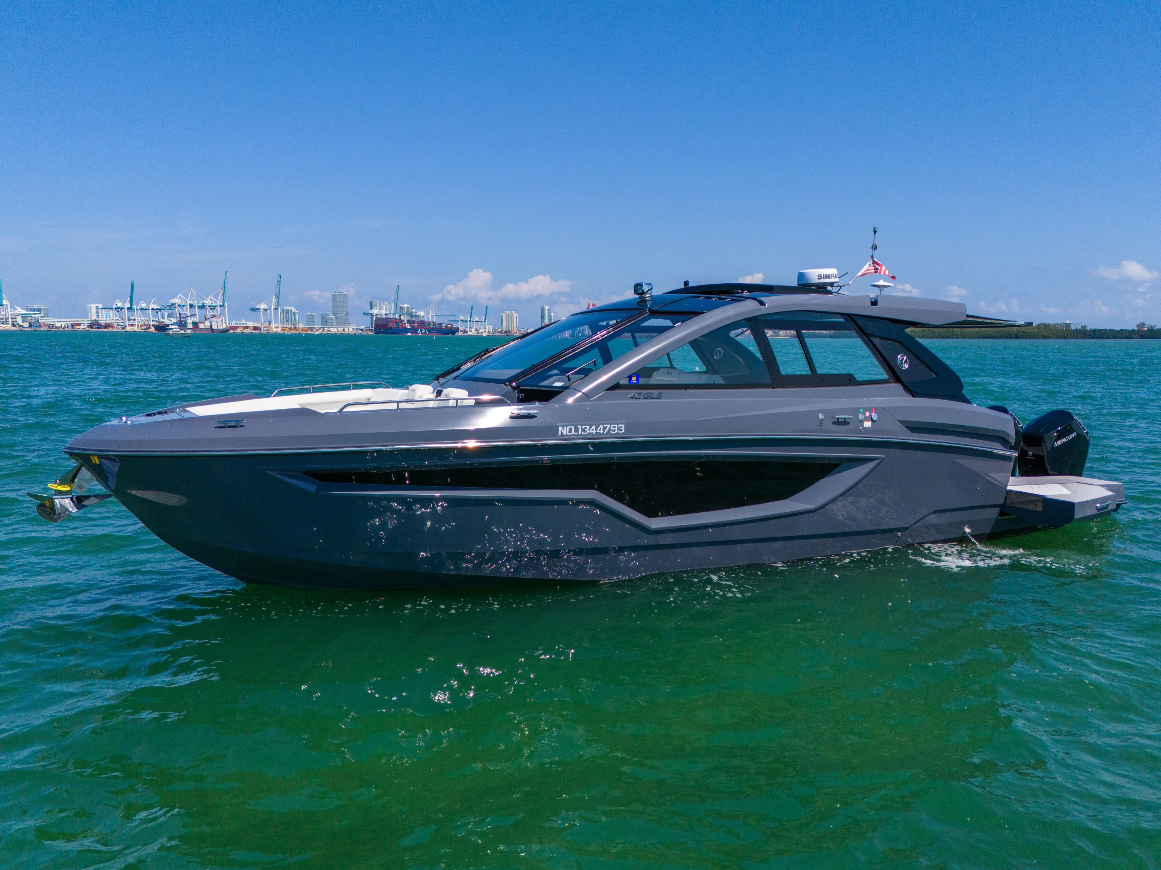  Yacht Photos Pics 2023 Cruisers Yachts 42 GLS OB on water, sleek design, sunny day, city skyline background.