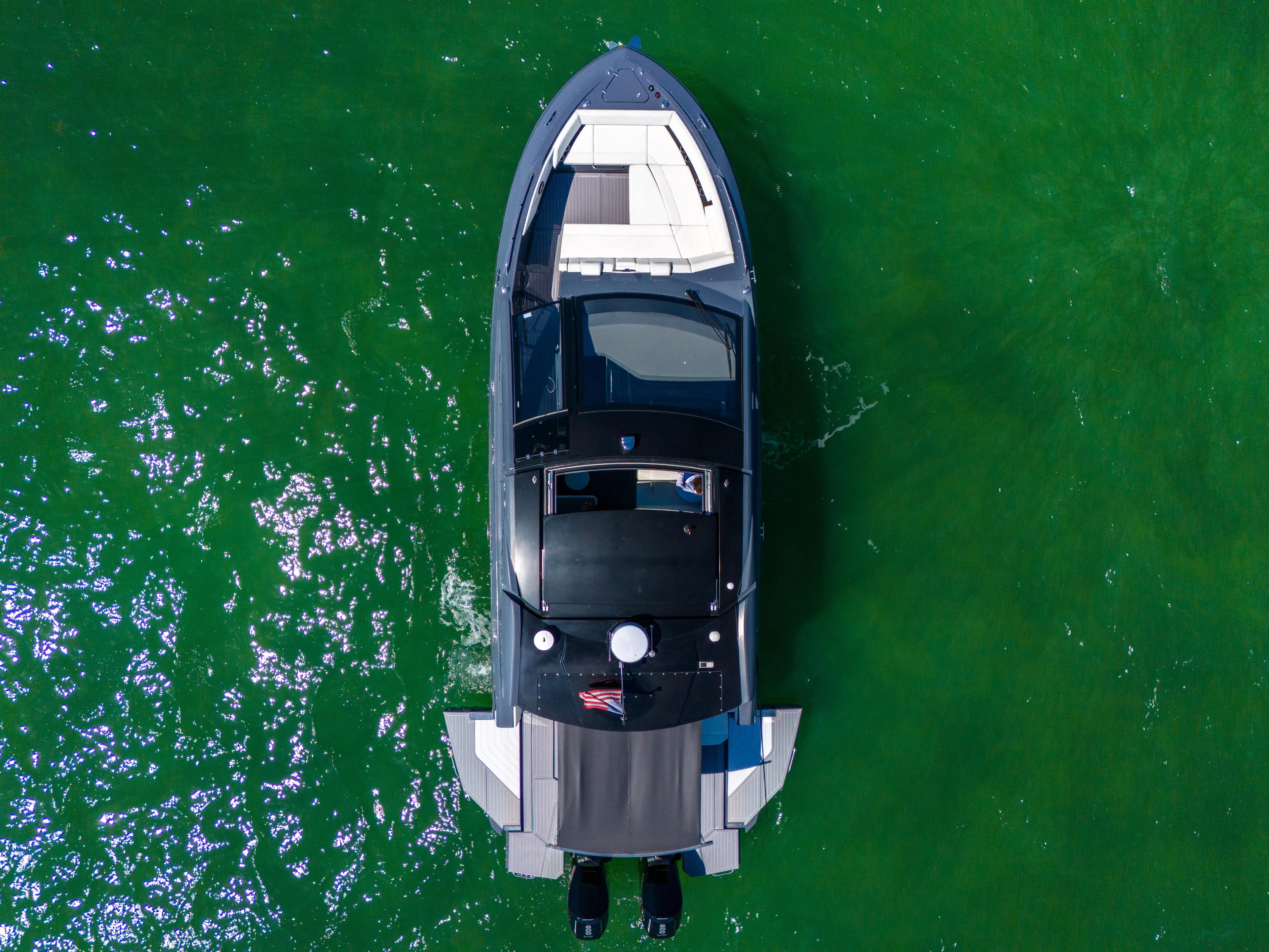  Yacht Photos Pics 2023 Cruisers Yachts 42 GLS OB on vibrant green water, aerial view.