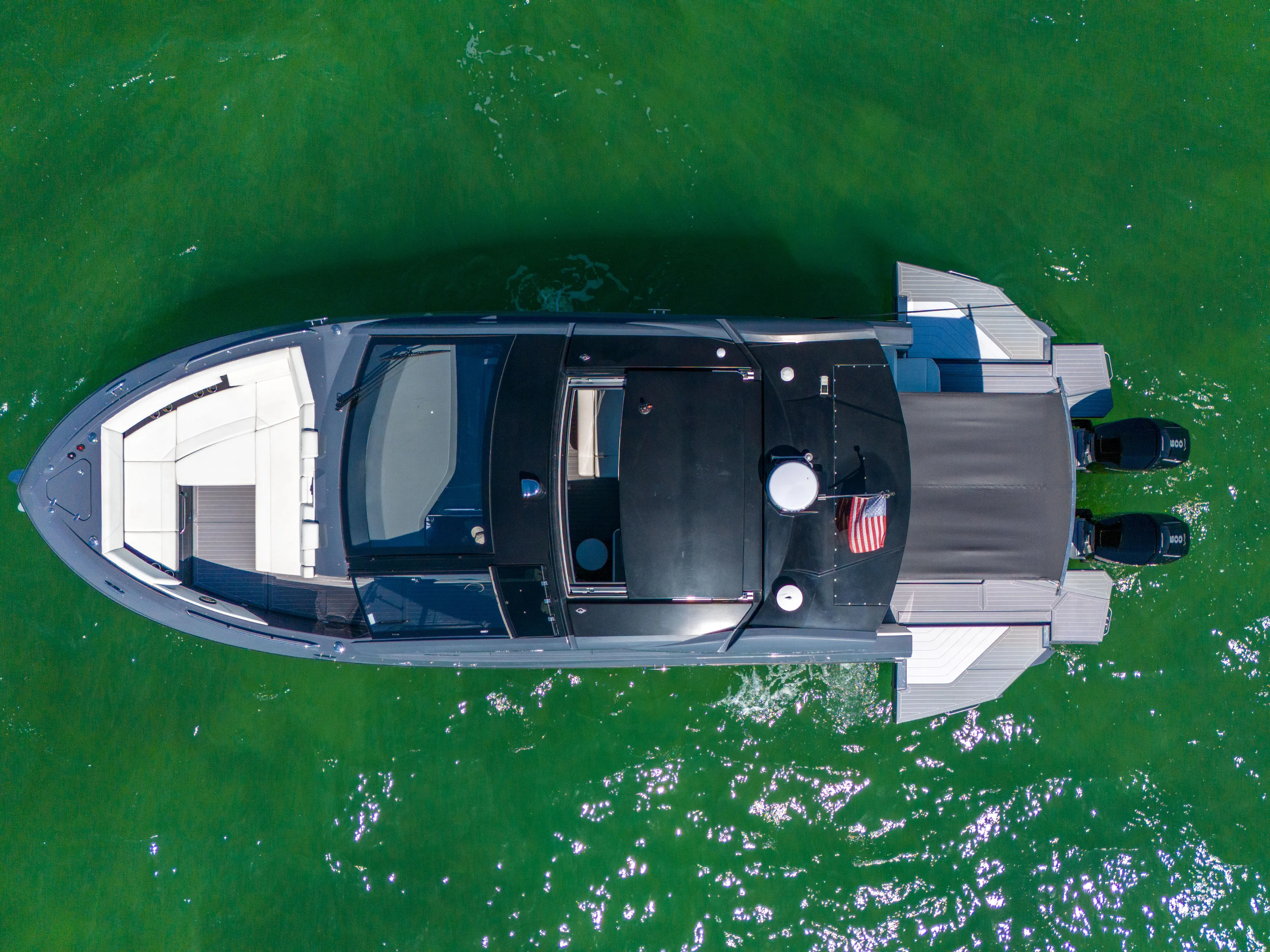  Yacht Photos Pics 2023 Cruisers Yachts 42 GLS OB on vibrant green water, aerial view.