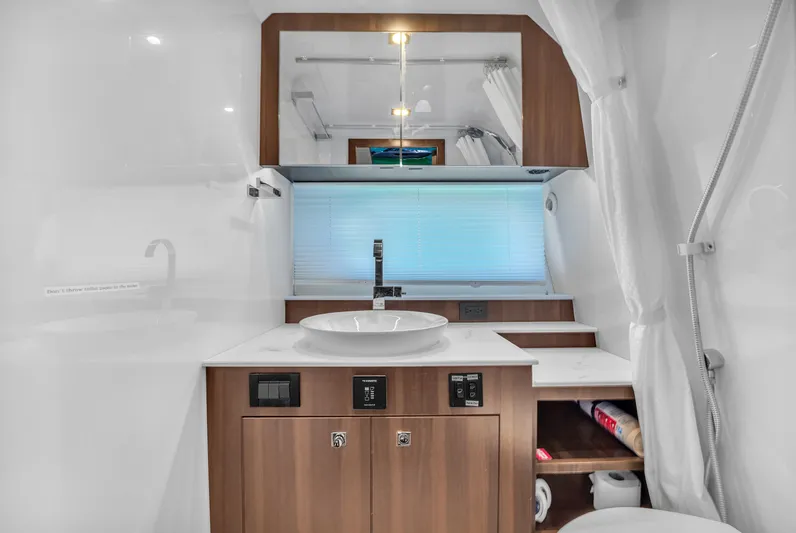  Yacht Photos Pics 2023 Cruisers Yachts 42 GLS OB bathroom with modern sink and wooden cabinetry.