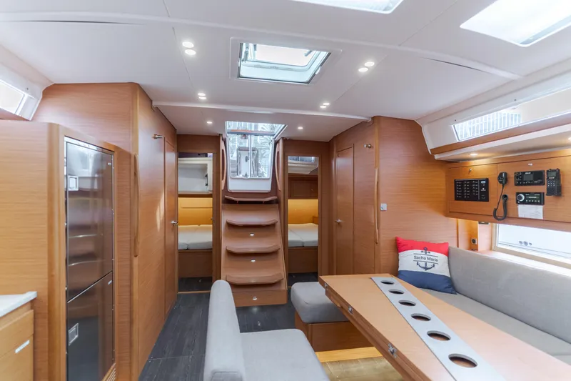 Sacha Marie Yacht Photos Pics Luxurious interior of 2024 Dufour 470 yacht with modern wood finish and seating area.