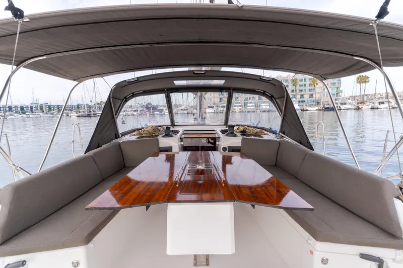 Sacha Marie Yacht Photos Pics 2024 Dufour 470 yacht cockpit with wooden table and cushioned seating.