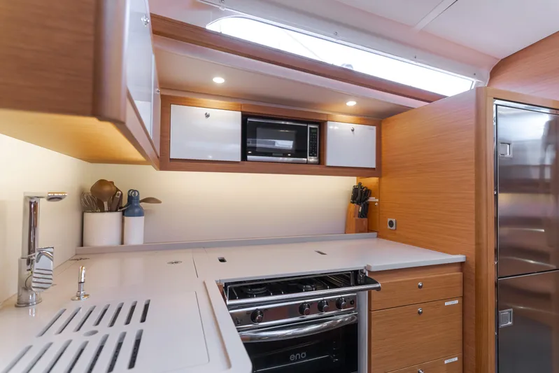 Sacha Marie Yacht Photos Pics Modern kitchen interior of 2024 Dufour 470 yacht with sleek appliances and wood finish.