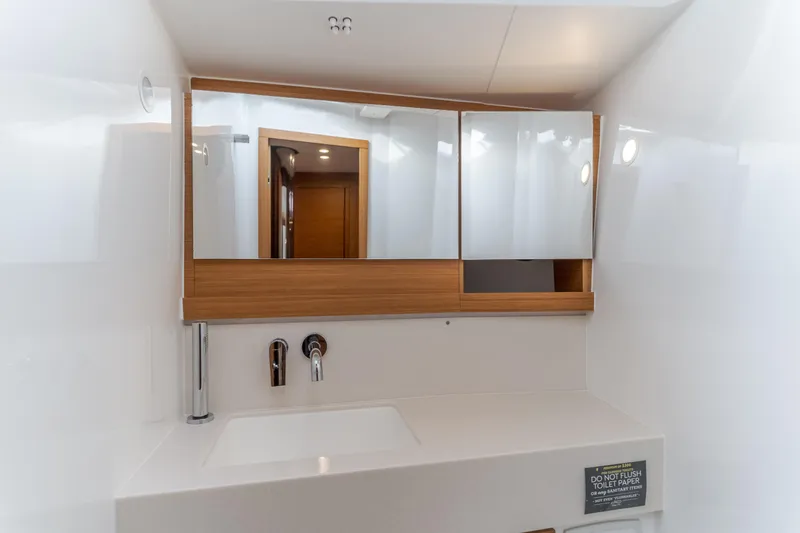 Sacha Marie Yacht Photos Pics Modern bathroom interior on 2024 Dufour 470 yacht, featuring sleek sink and mirrored cabinet.