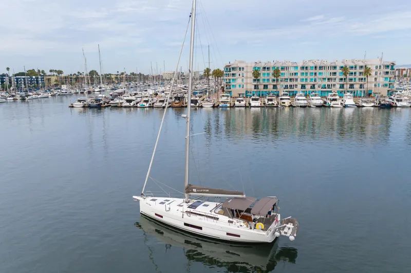 Sacha Marie Yacht Photos Pics 2024 Dufour 470 sailboat in marina, calm waters, modern waterfront buildings.