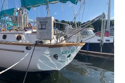 Shamrock Yacht Photos Pics 1984 Shannon 51' Center Cockpit sailboat docked in a marina, featuring teal accents.