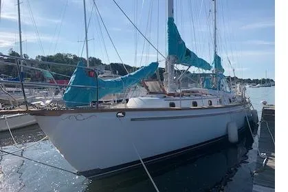 Shamrock Yacht Photos Pics 1984 Shannon 51' Center Cockpit sailboat docked, featuring blue sail covers and classic design.