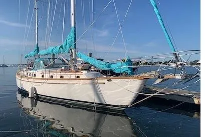 Shamrock Yacht Photos Pics 1984 Shannon 51' Center Cockpit sailboat docked on calm water under clear blue sky.