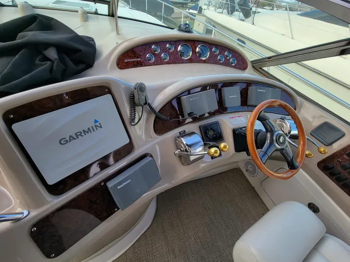  Yacht Photos Pics Cockpit of 2000 Sea Ray 460 Sundancer with Garmin navigation system and wood-trimmed steering wheel.