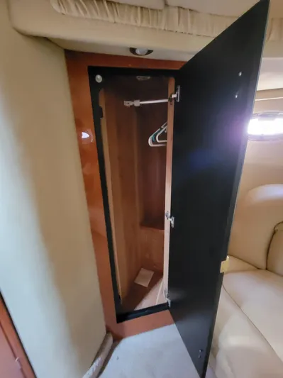  Yacht Photos Pics Open closet inside 2000 Sea Ray 460 Sundancer yacht, featuring wooden interior and hangers.