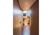 Interior hallway of 2009 Pershing 72' yacht with curved walls and wooden stairs.