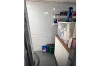 Storage area on a 2009 Pershing 72' yacht with cleaning supplies and containers.