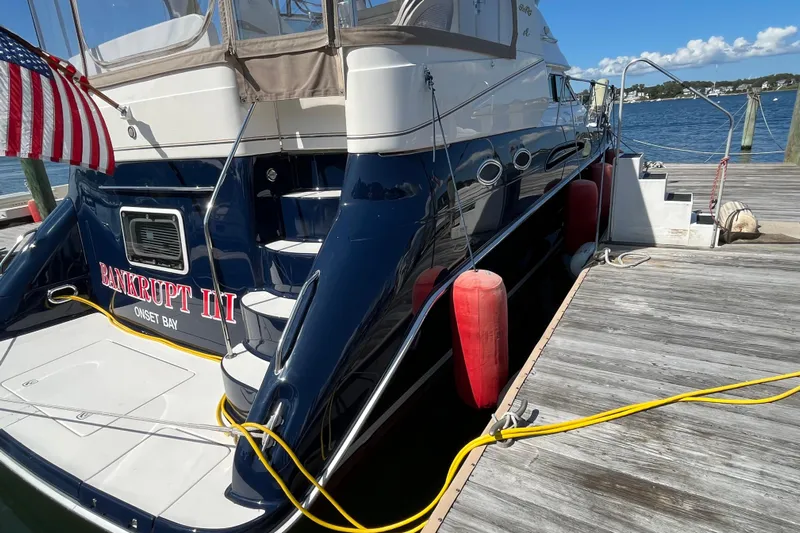  Yacht Photos Pics 1997 Sea Ray 420 Aft Cabin yacht docked with American flag and red fenders.