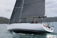 Sailing yacht "Murray Burns Dovell 62" from 1999 on the water, featuring sleek black sails.