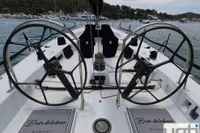 Dual steering wheels on a 1999 Custom Murray Burns Dovell 62 yacht, docked in a marina.