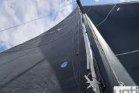 Sail of a 1999 Custom Murray Burns Dovell 62 yacht against a blue sky.