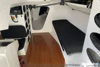 Interior of 1999 Custom Murray Burns Dovell 62 yacht with wooden flooring and seating.