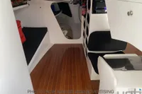 Interior of 1999 Custom Murray Burns Dovell 62 yacht with wooden flooring and seating.
